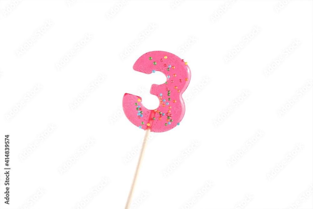 lolipop in number 3 shape. sweet candy on wooden stick. pink number 5 isolated on a white background. anniversary selebration or birthday party. lolipop in number 3 shape. sweet candy on wooden stick. pink number 5 isolated on a white background. anniversary selebration or birthday party.