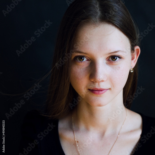 portrait of a young woman in black background