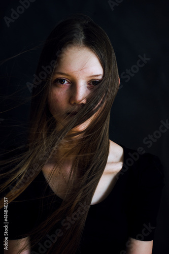 portrait of a young woman in black background