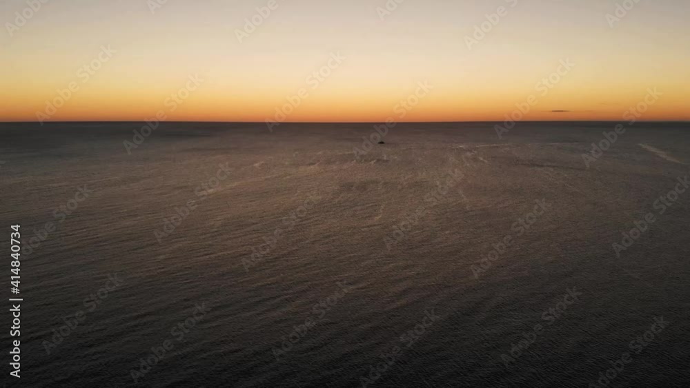 Drone flying above sea and a boat in the background