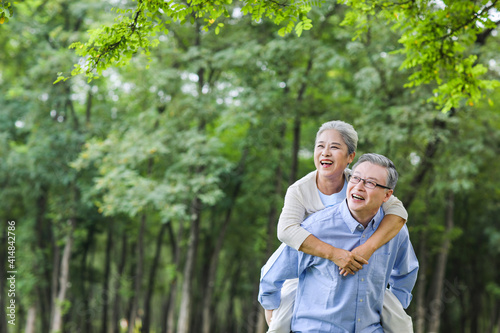Old man looking at the scenery with his wife behind his back in the park