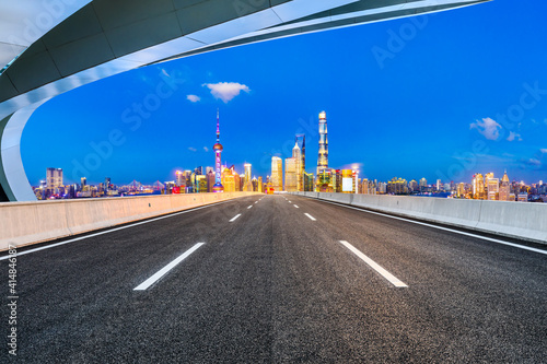 Empty asphalt road and Shanghai skyline with buildings at night.