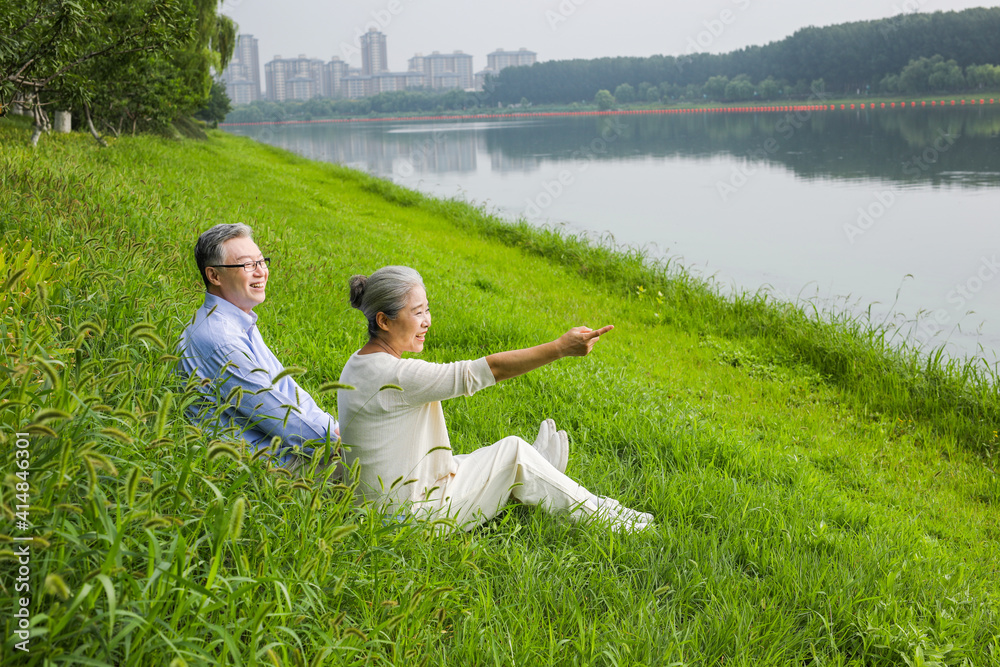 Happy old couple watching the scenery by the river