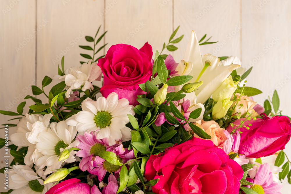 Mixed bouquet of different flowers on a wooden background, top view