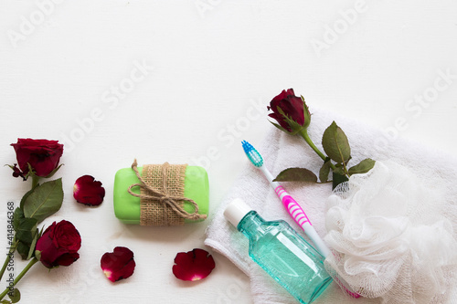 Fototapeta Naklejka Na Ścianę i Meble -  mouthwash ,toothbrush  health care for oral cavity with terry cloth ,herbal soap spa for health care body skin with red rose flower prepare a bath on background white 