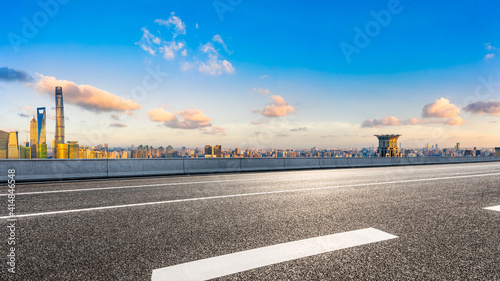 Empty asphalt road and Shanghai skyline with buildings at sunset.