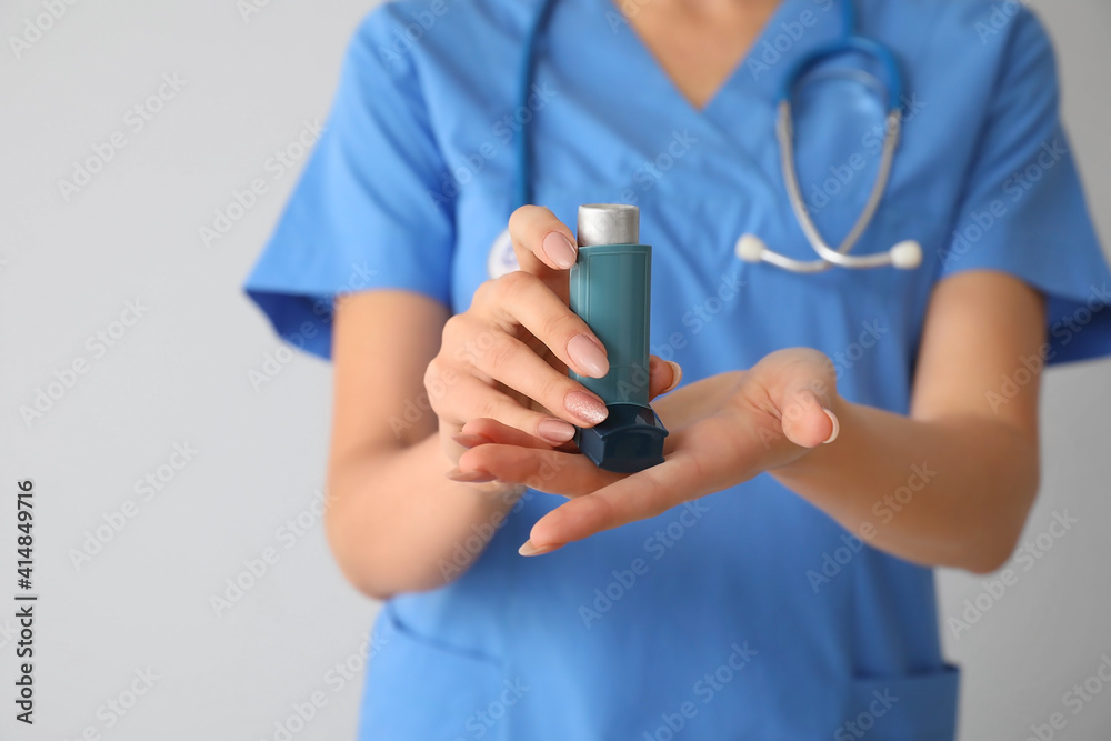 Allergist with inhaler on light background, closeup Allergist with inhaler on light background, closeup