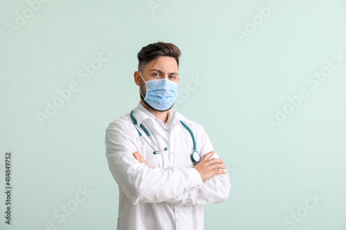 Male doctor on color backgr...