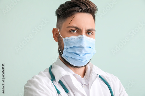 Male doctor on color backgr...