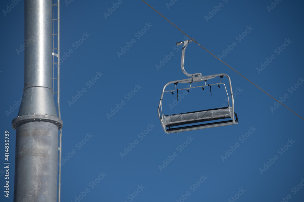 empty ski lift chair against blue skies silver metallic chair on cable line at ski resort horizontal format space for type empty ski lift chair against blue skies silver metallic chair on cable line at ski resort horizontal format space for type