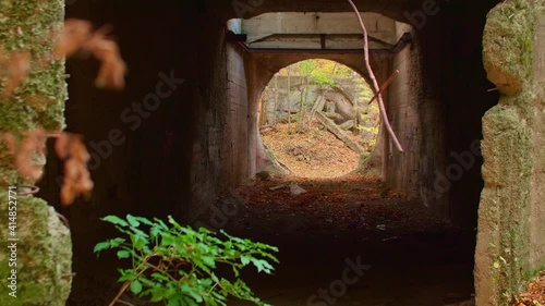 View of ruined enter to abandoned and ruined mine. View through tunnel and round hole. photo