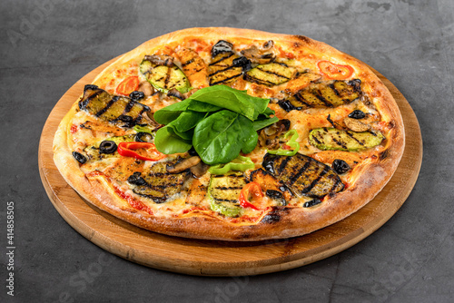 vegetarian pizza with eggplant and zucchini on stone table photo