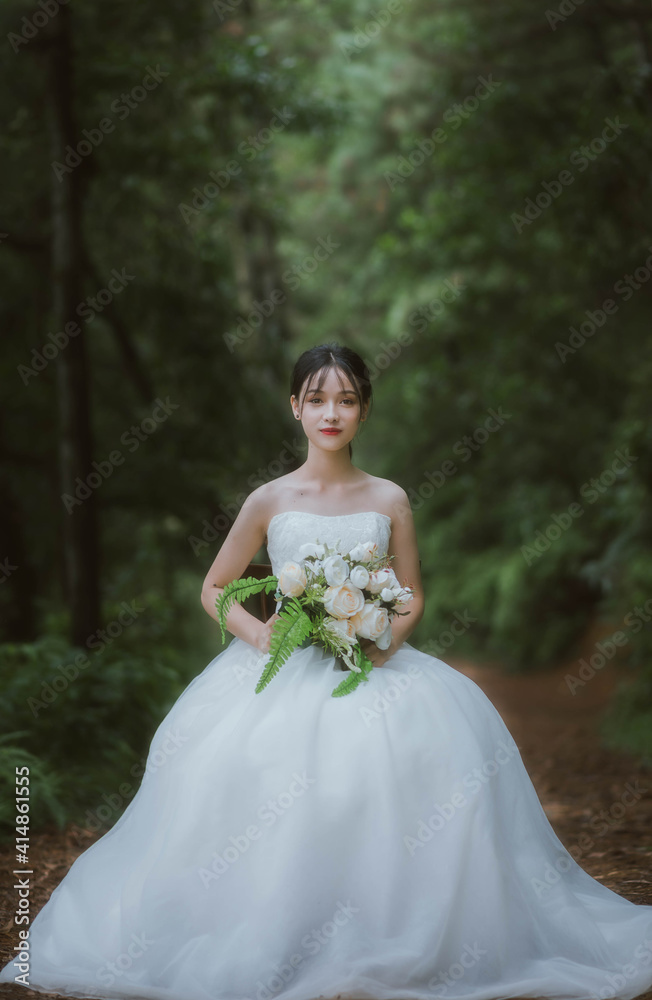 portrait of asian bride in wedding dress in forest and overcast day
portrait of asian bride in wedding dress in forest and overcast day