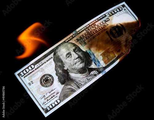 One Hundred Dollars are burning on a black