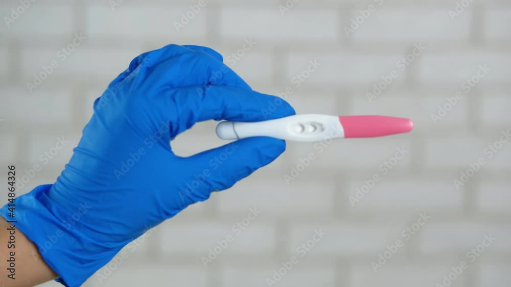 Close-up pregnancy test. Doctor's hand in gloves with a pregnancy test. Close-up pregnancy test. Doctor's hand in gloves with a pregnancy test.
