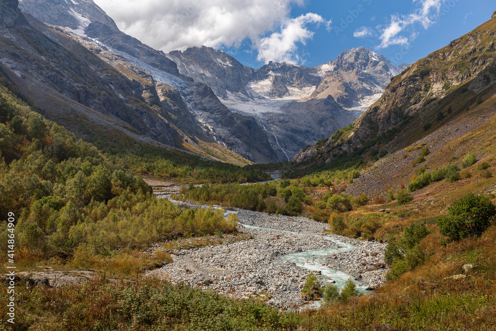 Picturesque mountain landscape with river and peaks on a sunny day. Caucasus Mountains. National Park North Ossetia - Alania