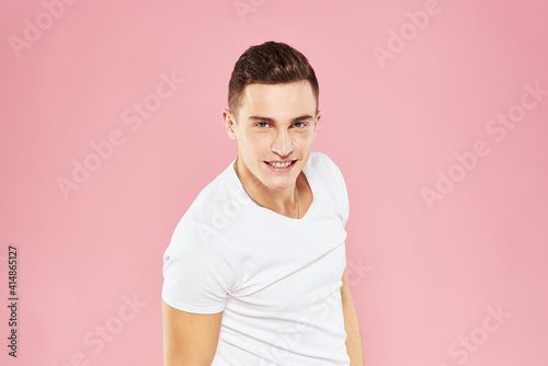 Cheerful handsome man in white t-shirt emotions pink isolated background