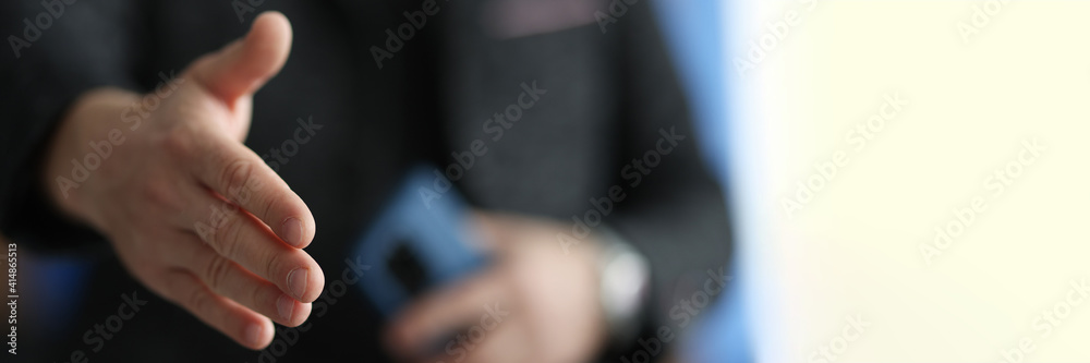 Man stretches out his hand for handshake closeup. Conducting business deals concept. Man stretches out his hand for handshake closeup. Conducting business deals concept.