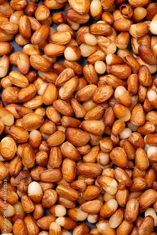 Background of peeled pine nuts from Siberia, milky color with a yellow dry skin. Background of peeled pine nuts from Siberia, milky color with a yellow dry skin.
