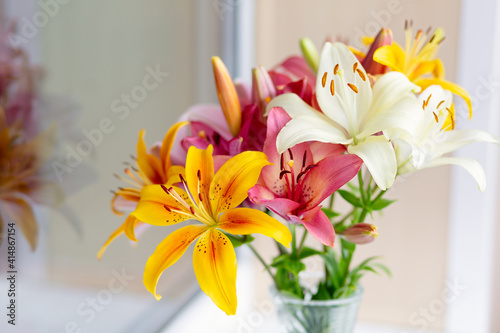 A bouquet of lilies in a vase in daylight