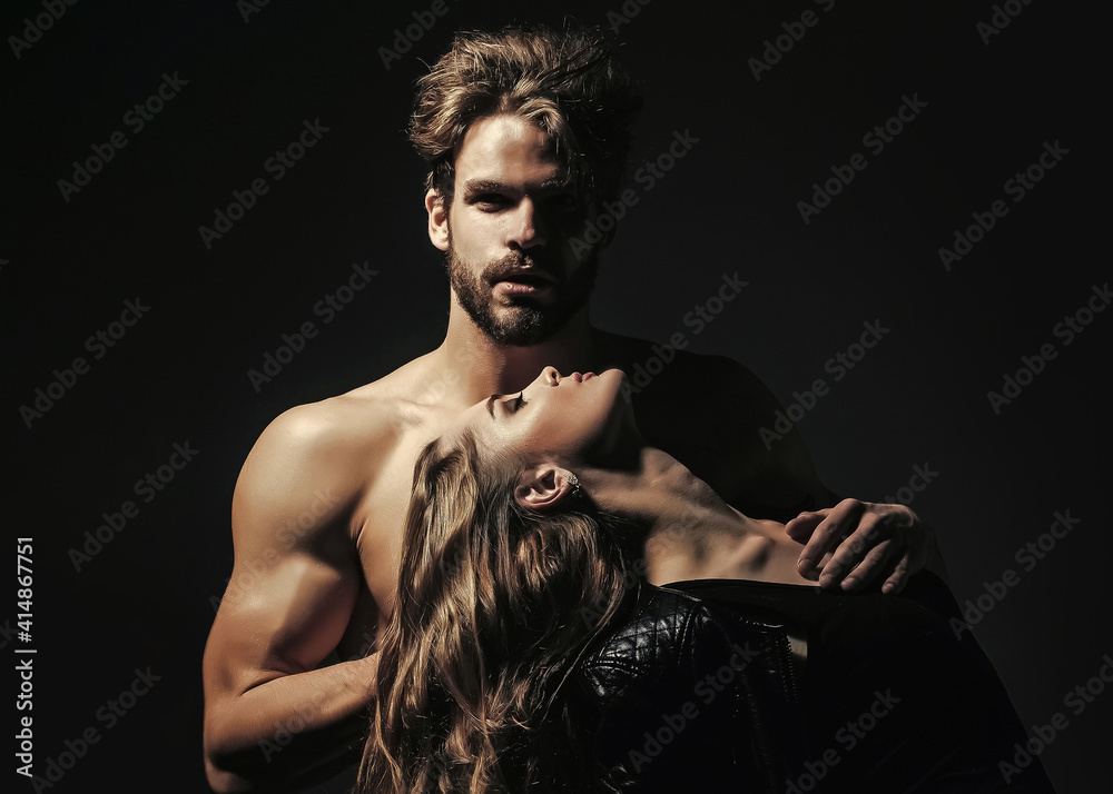 Man with muscular torso and sensual woman. Couple in love on black ...
