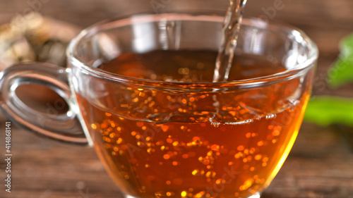 pouring tea to a teacup, close-up