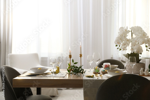 Beautiful Easter table setting with orchid flowers indoors