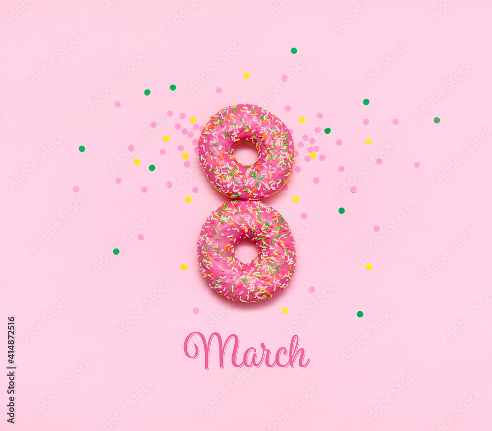 A greeting card for women's day with donuts in the form of the number eight, covered with pink icing, lying on a pink background. Beautiful pink buns, presented for the holiday on March 8. A greeting card for women's day with donuts in the form of the number eight, covered with pink icing, lying on a pink background. Beautiful pink buns, presented for the holiday on March 8.