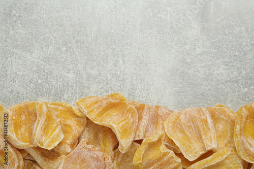 Delicious dried jackfruit slices on light grey table  flat lay. Space for text