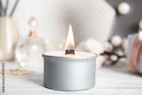 Beautiful burning candle on white wooden table, closeup