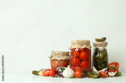 Pickled tomatoes, cucumbers, adjuca and ingredients on white background