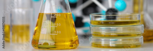 Glass test tubes with yellow viscous liquid stand on table in chemical laboratory closeup. Checking the quality of petroleum products refining concept.