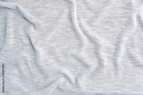 Background is made of gray textile material, the texture of a piece of clothing