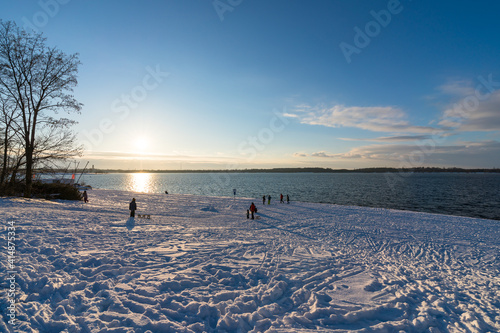 People enjoying snow at the Cospudener Lake in Leipzig photo