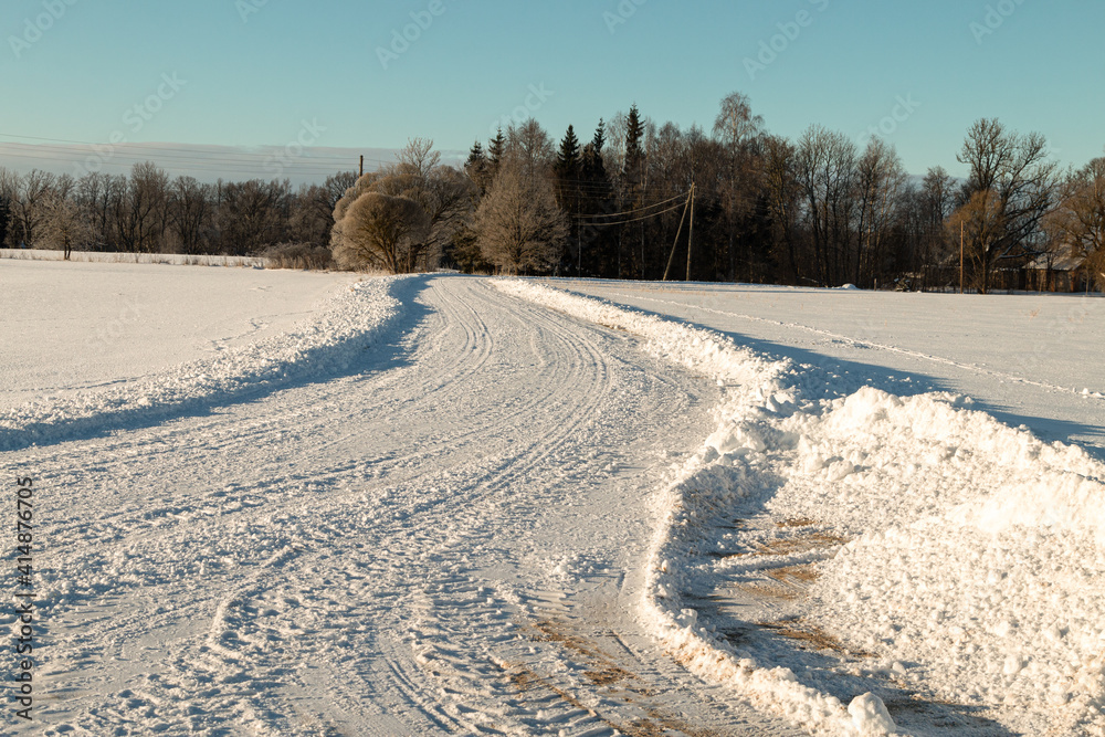 Country road through the winter countryside on a sunny and cold day