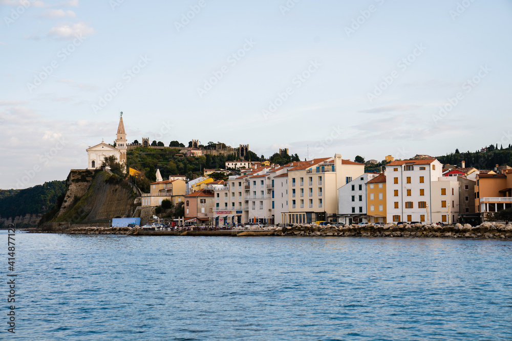 Piran at sunset, view from the sea toward the old town and church Slovenia, Europe