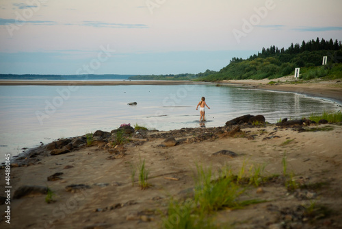 girl playing on the riverbank, selective focus