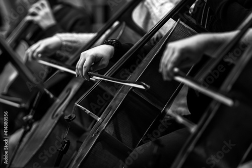 Hands of a musician playing the cello in an orchestra in black and white 