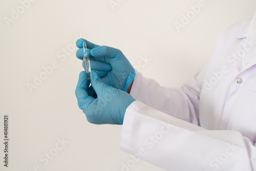 Doctor's, nurse, healthcare worker hand in glove holding medical glass ampoules on white background. Preparing for injection.