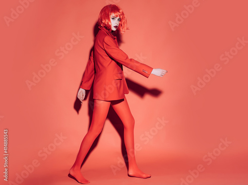 Woman in red. Fashion concept. Girl on mysterious face in red formal jacket, red background.