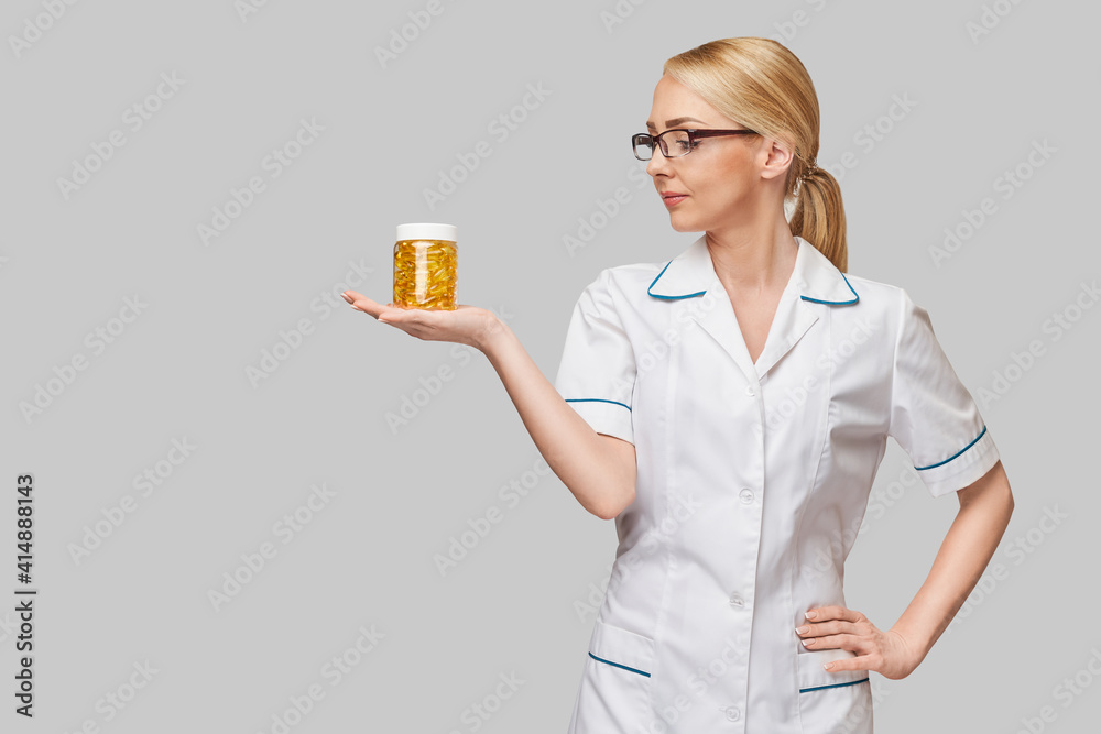 Health care and diet concept - doctor nutritionist or cardiologist holding fish oil in capsules for vitamin D and omega-3 fatty acids Health care and diet concept - doctor nutritionist or cardiologist holding fish oil in capsules for vitamin D and omega-3 fatty acids