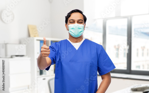 Фотография healthcare, profession and medicine concept - indian doctor or male nurse in blu
