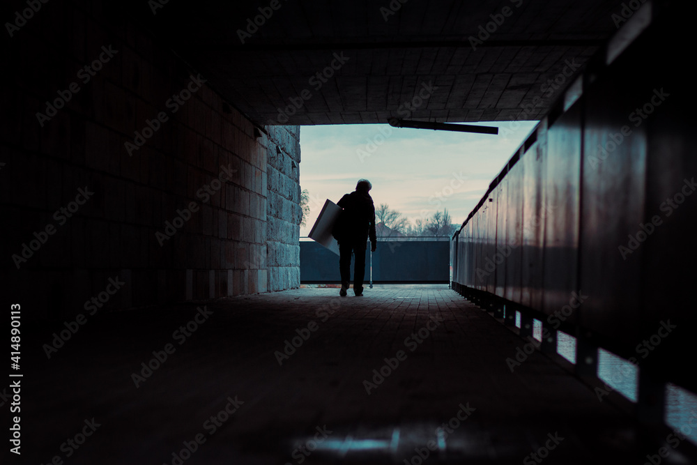 silhouette of the man in the passageway under the bridge