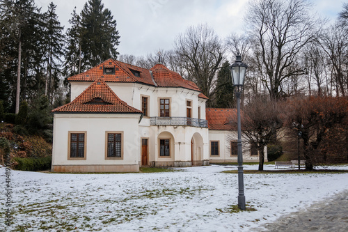 Baroque white benedictine monastery Brevnov with church, Pavilion Vojteska, Garden and park, abbey under snow in winter day, Prague, Czech Republic photo