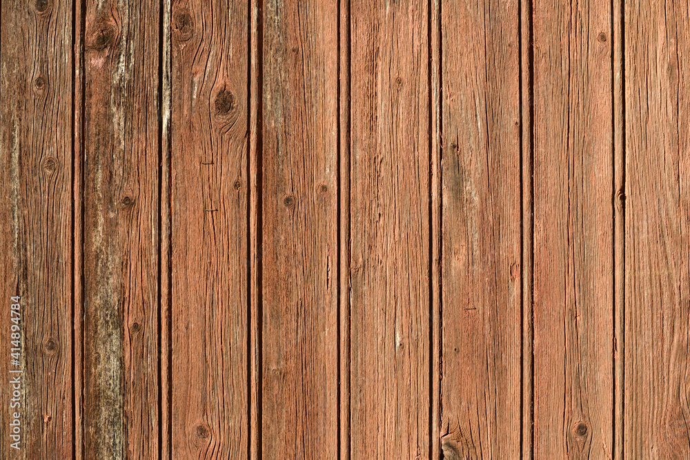 Naklejka premium Texture d'une vieille porte en bois avec des planches marron au soleil