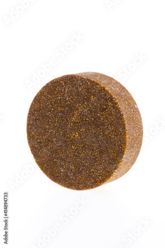 Brown round piece of soap on a white background. Bathroom.