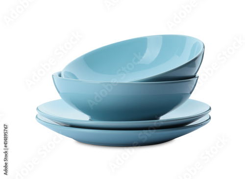 Stack of clean plates and bowls on white background