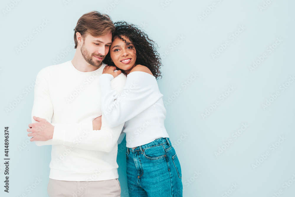 Smiling beautiful woman and her handsome boyfriend. Happy cheerful multiracial family having tender moments on grey background in studio. Multiethnic models hugging. Embracing each other.Love concept Smiling beautiful woman and her handsome boyfriend. Happy cheerful multiracial family having tender moments on grey background in studio. Multiethnic models hugging. Embracing each other.Love concept
