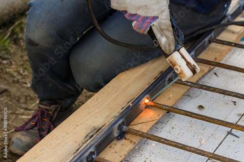 A man welds a metal frame to build an aviary, welding metal close up. © Niko_Dali