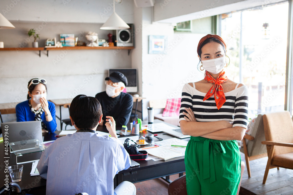 Obraz premium マスクをしたデザイン事務所で働くスタイリッシュな女性